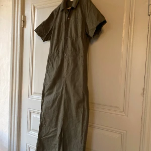 Levis jumpsuit women - En snygg jumpsuit från Levis som bara är använd tre gånger. Säljer för att den är lite för kort. Khakifärg. Knappar, fickor. Raka ben. Bra kvalitet.  Storlek large. Liten i storlek. Nypris 1200kr