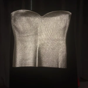 Silver bandeau topp - En jätte fin silvrig bandeau topp som passar perfekt till fester eller nyår. Skulle jätte gärna vilja ha den men den var tyvärr för liten. Den skulle absolut passa dig i xs eller i s men med mindre byst! Toppen är inte använd en enda gång. Hör av vid fråg