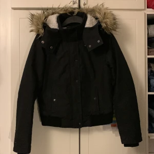 Hollister jacka - Svart jacka med pälsluva från hollister i storlek xs. Säljer för den va förliten för mig men den e i helt okej skick annars. Dragkedjan e sönder men knapparna fungerar fortfarande. Skriv gärna om du har frågor, e intresserad eller vill ha fler bilder! 
