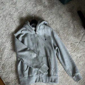 Polo zip-hoodie - Polo zip hoodie. Är i ull modellen använd få tal gånger. Inga snören då den är utdragna. Väldigt skön då de är ull på insidan. Hör av dig vid fler frågor