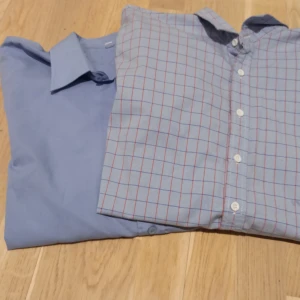 Blåa skjortor - Den rutiga är i perfekt skick och är från märket Dressmann i storlek XL, men passar L Den blåa är från Tesco, storlek L De båda är väldigt fina och passar till alla tillfällen!  Se gärna mina andra liknande annonser👍