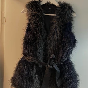 Päls väst  - Fake päls väst. Storlek S Har ett midjebälte som går att ta bort 