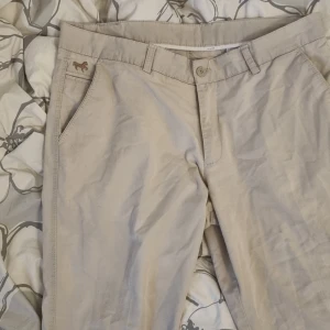 Baggy pants  - Säljer ett par blue racing  byxor i khaki färg. Har tyvär fått lite svart ink färg i nedre delen av byxorna på benen men allt annat är bra.