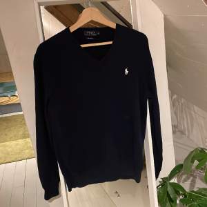 En mörkblå v-ringad pullover från Polo Ralph Lauren. Väldigt bra skick och använd ett fåtal gånger. 