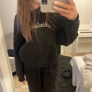 Tröja - Svart tröja. Med märkt ”atelier 22” på framsidan. Lent, glansigt och lyxigt material inuti. Använt endast en gång. Storlek xs, normal passform.
