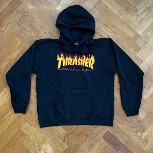Thrasher hoodie svart  - Thrasher hoodie svart med den klassiska eldloggan. Storlek M, 38-40