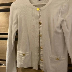 Kofta - Vit kofta med guldiga knappar från STOCK LM. Utan tydligt slitage. 