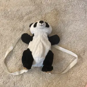  En jättegullig panda väska som är svart och vit med öppning på ryggen och skor 