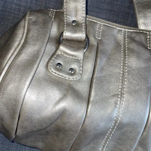 Silvrig handväska - Oanvänd väska i silvrig färg! Med innerfickor och dragkedja. Köpt second hand🪩
