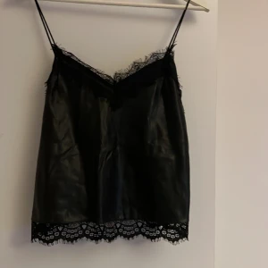 Linne Läder - Linne i fakeläder och en spetskant. 