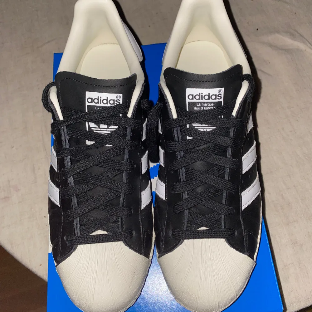 Adidas Orginals Superstar 82 skor i svart. Storlek 45,5. Använda 2 gånger. Skick 9,5/10.  Nypris: 1549kr. Mitt pris: 799kr.  Original box finns med. Skriv för fler foton. . Skor.