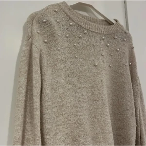 Stickad tröja - En fin stickad tröja med vita pärlor på. Tröjan är val använd och är därmed nopprig (se bild 3), priset är därför lågt. Skulle säga att den är stor i storleken. Skriv för mer information. TRYCK INTE PÅ ”KÖP NU” UTAN SKRIV TILL MIG FÖRST!💗💗