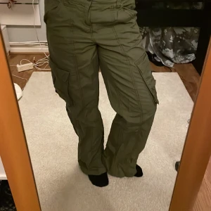 Snygga cargobyxor  - Ettt par snygga cargobyxor som kanske använts 3 gånger. Innerbenslängden är ca 74 cm men de är uppsydda ca 2. De har inga defekter och är luftiga!