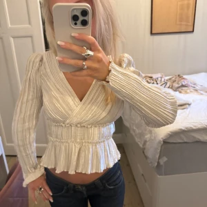 Långärmad blus - Säljer denna superfina glänsande blusen från other stories i storlek 32