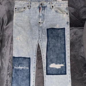 Dsquared2 ljusa jeans med tryck  - Unika Dsquared2 jeans i storlek 52 (L), helt nya aldrig använd. Kvitto och box finns, inköpta på FARFETCH för ca 4500kr. Väldigt fina nu iför simmare. Hör av er för fler bilder. 