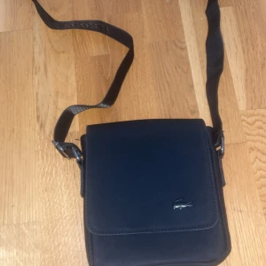 Lacoste väska - Hej säljer min Lacoste väska den är i nytt skick knappt använd och det finns inga deffekter eller fel på väskan
