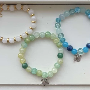 Egengjorda pärlarmband  - Tre stycken egengjorda pärlarmband i olika färger med olika berlocker. 