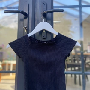 Svart t-shirt Lindex - En svart t-shirt från Lindex som går till midjan i storlek 128/ 7-8y.