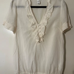 Vacker blus med volang, H&M, stl 36 - Vacker blus med volang  Benvit, cremevit  I ok skick 