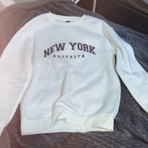 Tröja - Vit tröja med blå text som säger New York Brooklyn. Köpt från shein i storlek xs, passar nog S också. Använd några gången men i bra skick. Pris kan diskuteras.