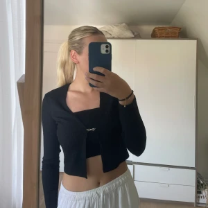 Svart stickad kofta från NLY - Svart söt stickad kofta med silvrigt spänne från NLY i storlek S 