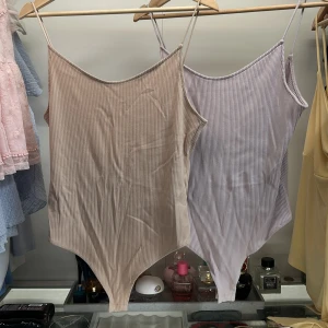 Två bodys med öppen rygg en Beige och en lila. - Ny skick 