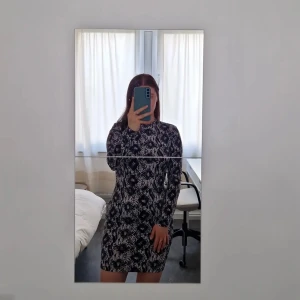 Kort klänning  - Superfin kort klänning i blandning av polyester och elastan. Så skönt material och sitter jättefint på.  Lite konstigt tagen ryggbild då det ser ut som att den är för stor men det är pga posen. Har burit den en gång och plagget har inga defekter.