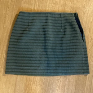 Minikjol, grön, S/M - En mini kjol med randigstruktur. Mer grön än på fotona, skulle uppskatta storlek S/M.