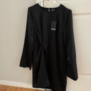 Siden klänning  - Pieces. Aldrig använda. Prislapp kvar. Mellan/kort. Funkar till stövlar!! Något åtsittande i midjan 