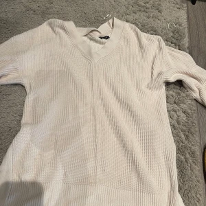 Tröja - Fin stickad tröja. Storleken M. Mjölkvit färg. Ribbad och lite öppet vid sidan om. Som man nu ser på bilden. Använt den 5 gånger
