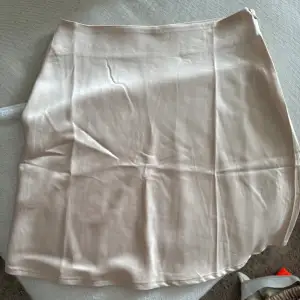 Gräddvit kjol i satin från Gina tricot