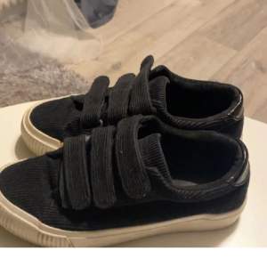 Svarta sneakers med kardborreband.