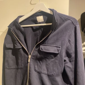 Mörkblå overshirt - Säljer nu min mörkblåa overshirt då den inte används! Den är nästan som ny! Nypris 999kr