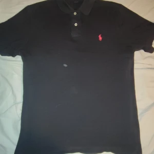 Ralph Lauren piké - Säljer en svart Ralph Lauren piké i storlek M då den inte används längre, den är i väldigt fint skick. Här av er om ni har några frågor angående priset osv