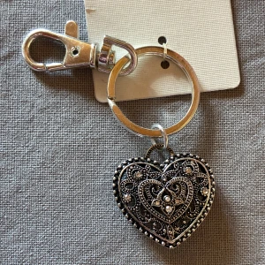 Nyckelring med silvrig hjärtberlock -  Jättefin nyckelring med silvrig hjärta i vintage stil med massa fina små detaljer. Rostfritt!