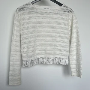 Vit stickad tröja, H&M  - Gullig stickad ihålig tröja, men små hängande trådar från H&M. Passar perfekt till sommaren 🌸☀️ Den är lite sliten vid vänster sida, men inget man tänker på💕 Pris kan diskuteras 