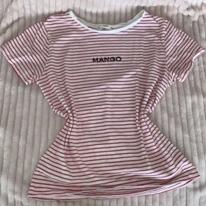 Randig T-shirt från Mango - Oanvänd!☺️ Superfin röd-vit randig t-shirt med Mango loggan ovanpå! Perfekt nu till våren/sommaren! Det står storlek M på tröjan men passar folk som bär S!