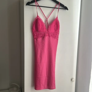 Nattlinne från BikBok - Oanvänt rosa nattlinne med spets från BikBok. Det är korsat i ryggen och är jättegulligt. Det är i storlek S och slutar ungefär vid mitten av låret. Banden är justerbara 💗