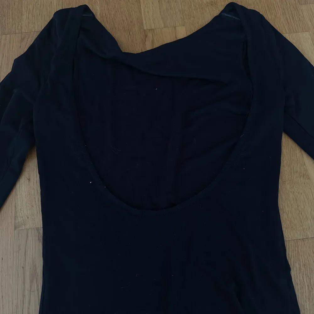 Långärmad tröja med öppen rygg från veromoda, köpt för 299. Den ser lite blå ut på bilden med den är i färgen svart.. Tröjor & Koftor.