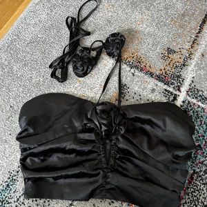 Svart topp - Svart jättefin sommar topp med fina blom-detaljer. Dragkedja på sidan och snörning vid halsen, aldrig använd😊