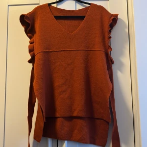 Stickad tröja - Köpt utomlands. Fin tröja som går att knyta fram eller bak.