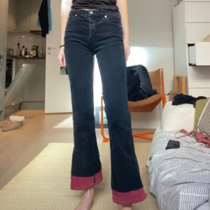 Omsydda manchesterbyxor - Omsydda av tidigare ägare. Rött tyg i botten. Svarta manchesterbyxor. Armani jeans