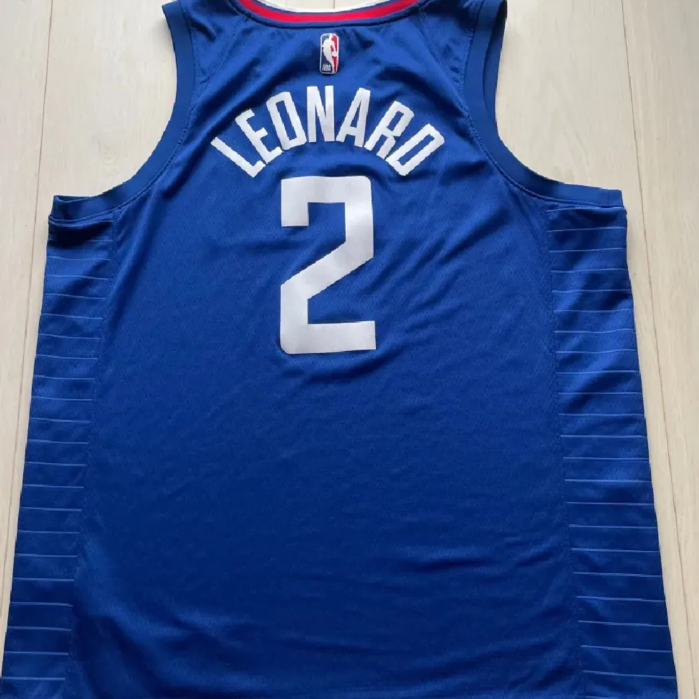 Los Angeles Clippers Swingman Jersey med Kawhi Leonard på ryggen (#2). Köpt sommaren 2022 för 999 kr och har använts sparsamt och är därför i gott skick. . T-shirts.