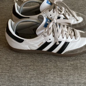 Addidas Samba - Snygga vita sambas bra skick pch perfekta inför våren/sommaren. Använda vid få tillfällen eftersom att de inte riktigt passade. Storlek 42 köpta på boozt för 1300kr. Skriv vid intresse priset kan diskuteras vid snabb affär.