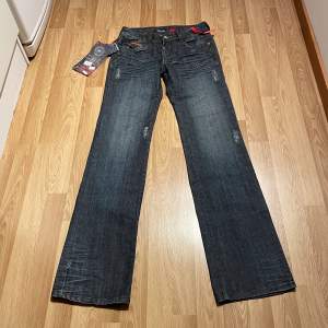 (36) lågmidjade bootcut jeans med specialfickor, helt nya med lappar kvar. Midjemått rakt över: 35cm, innerbenslängd: 85 cm. Stretchiga! 🩵