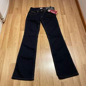 (35) lågmidjade bootcut jeans från Tommy Hilfiger helt nya med lappar kvar. Svart/ möööörkblå färg, stretch så passar större än måtten. Midjemått rakt över: 33cm, innerbenslängd 85cm 🩵