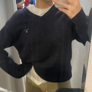 GANT tröja - Finstickad vringad marinblå tröja från GANT. Superfin att ha med en vit t-shirt under!! Stl M, köpt second hand.