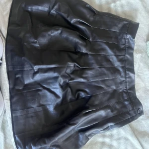 läderkjol - en jättesnygg läderkjol från Nelly. Använd men har inga defekter förutom ett litet hål under dragkedjan som inte syns överhuvudtaget. Storlek S💞