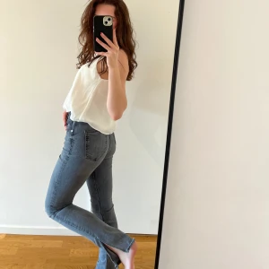 Gråa jeans - Mid waist / high waist med slits längst ner. Använda en gång!! Passar strl 32 och 34