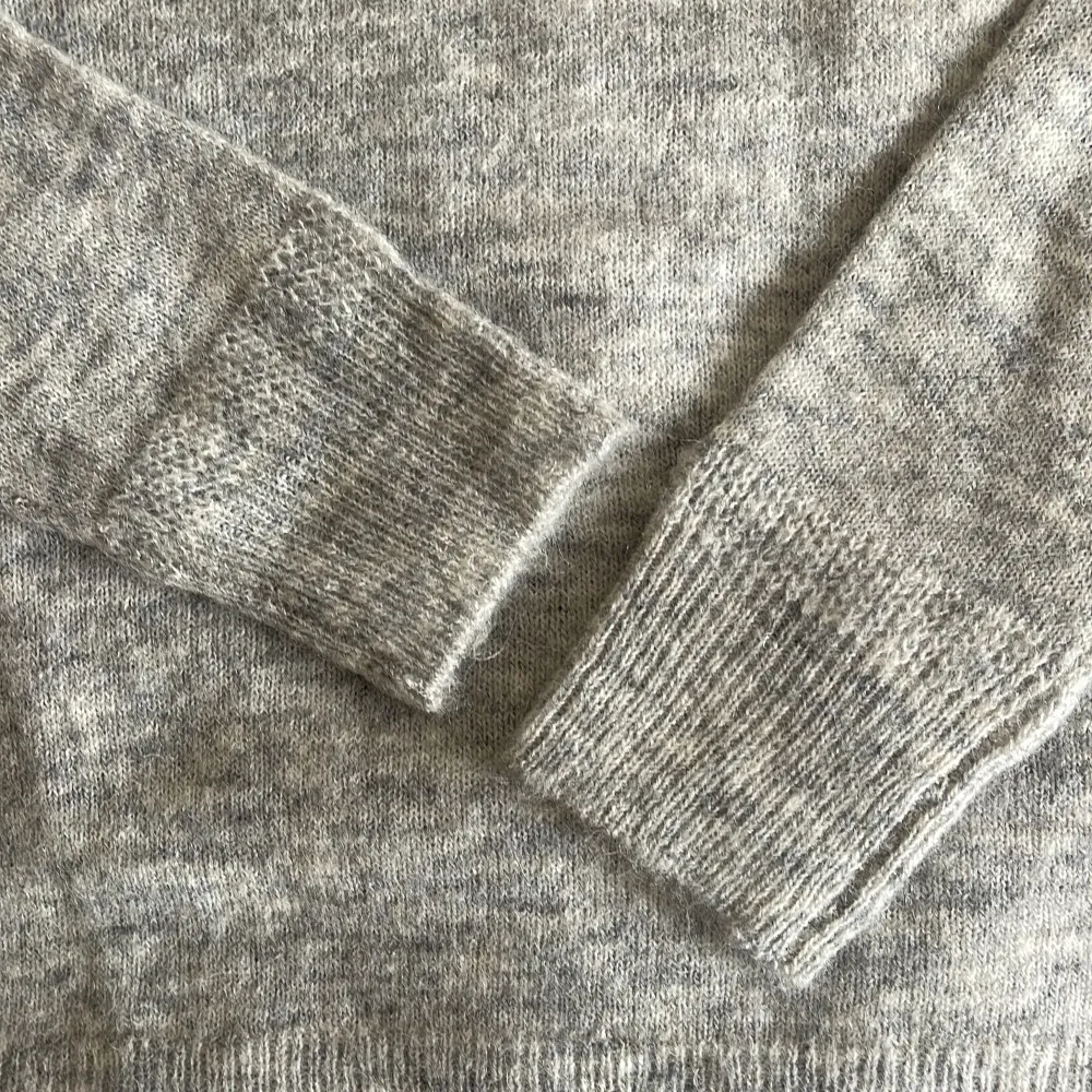 Oanvänd finstickad sweater i mjuk alpacka ull. Gråmelange m fin detaljestickning i muddsluten. Perfekt tunt stickad till vår och kyliga sommarnätter. Nypris 500:-. Tröjor & Koftor.
